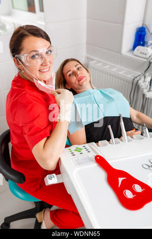 Erstaunlich, Lächeln, Blick von Oben auf die Zahnarzt seine schönen Patienten Prüfung in Zahnarzt s Büro. Stockfoto