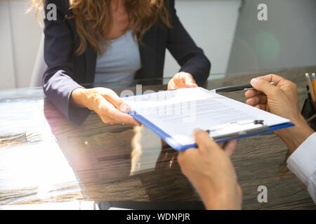 Nahaufnahme einer Real Estate Agent hilft Kunden bei der Besetzung Vertragsformular Stockfoto