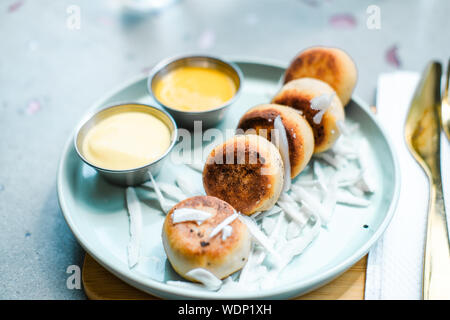 Vegan tofu Käse Pfannkuchen am blauen Platte, grauer Beton Tabelle. Sun Licht. Essen blog Fotografie Konzept Stockfoto