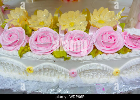 Mexiko Stadt/Mexiko - 12. Januar 2019: Details der Weißen Hochzeit Kuchen mit rosa Rosen und gelben Blumen Stockfoto
