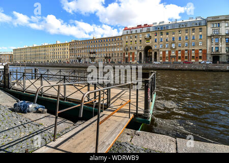 Ein obdachloser Mann schläft auf einem Bürgersteig in der Nähe eine Bootsanlegestelle an der Newa in St. Petersburg, Russland Stockfoto