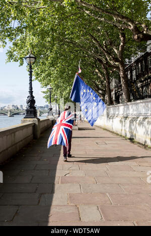 Rückspiegel von Anti Brexit Demonstrant das Tragen einer Union Flag und Durchführung einer EU-Flagge Spaziergänge entlang der South Bank der Themse nach einer Demonstration in London, Vereinigtes Königreich Stockfoto