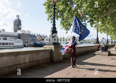 Ein anti Brexit Demonstrant das Tragen einer Union Flag und Durchführung einer EU-Flagge Spaziergänge entlang der South Bank der Themse nach einer Demonstration in London, Vereinigtes Königreich Stockfoto