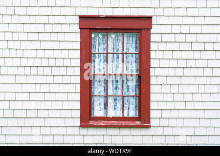 Alten rustikalen roten Fensterrahmen auf Cedar Schindeln mit verwitterten Peeling Stockfoto