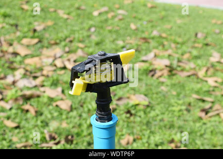 Nahaufnahme von Wasser Sprinkleranlagen für den Anbau mit grünem Rasen im Hintergrund Stockfoto