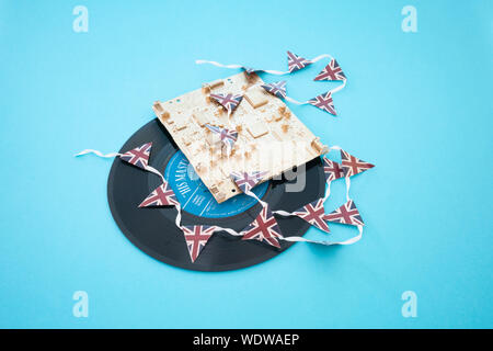 Alte vinyl singles Datensätze mit einem gold Computerplatine und Union Jack mini Bunting Stockfoto