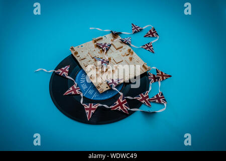 Alte vinyl singles Datensätze mit einem gold Computerplatine und Union Jack mini Bunting Stockfoto