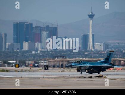 Eine F-16 Fighting Falcon Fighter jet bis zur 64Th Aggressor Squadron (AGR) Taxis auf einer Start- und Landebahn am Nellis Air Force Base, Nevada, Aug 8, 2019 zugeordnet. Der Aggressor Squadron Programm begann im Herbst 1972 mit der Aktivierung des 64. AGR. (U.S. Air Force Foto von Airman 1st Class Bryan Guthrie) Stockfoto