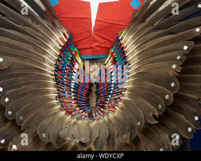 Nahaufnahme von einer Feder treiben dekoriert mit Stacheln und roten Weste getragen von einem männlichen Native American Dancer. Stockfoto