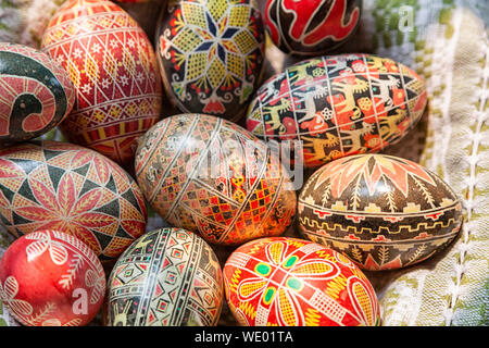 Ostern Eier aus Holz in nationales alte russische Muster auf einer Platte mit einem Küchentuch. Flach Zusammensetzung der bemalte Ostereier Stockfoto