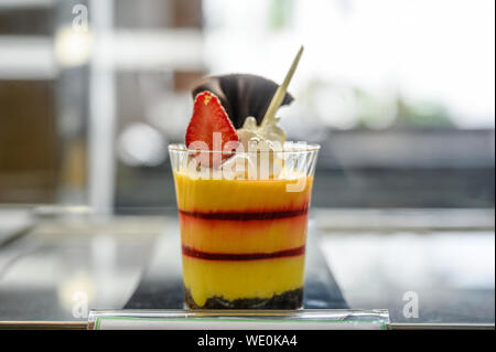Kuchen smoothie Mango mit Erdbeer Schichten mit Schokolade Cookies in Glas Schale Stockfoto