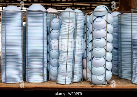 Blaue Schalen mit Cups in metallischen Storage auf Tisch gestapelt Stockfoto