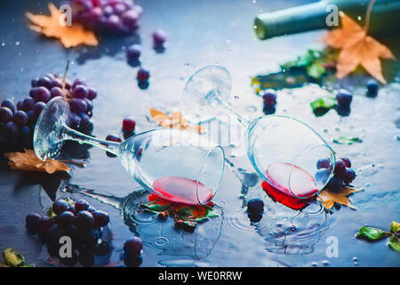 Hohe Weingläser mit Trauben und Laub unter Regen. Kreative Herbst trinken Fotografie mit Kopie Raum Stockfoto