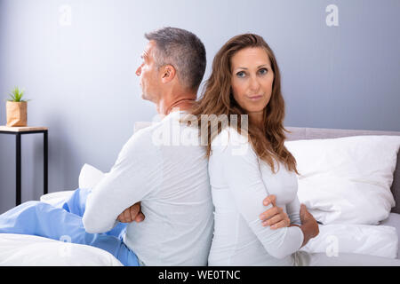 Seitenansicht des Verzweifelten Ehepaar Rücken an Rücken auf dem Bett Stockfoto