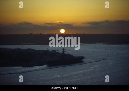 San Diego, Kalifornien, USA. 29 Aug, 2019. Die Sonne auf den Pazifischen Ozean hinter der Point Loma San Diego als Marine Flugzeugträger bei Naval Base Coronado, in der Bucht von San Diego angedockt ist. Credit: KC Alfred/ZUMA Draht/Alamy leben Nachrichten Stockfoto