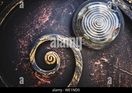 Gold Metall vintage strukturierten Hintergrund mit alten Glas runde Scheinwerfer und Schwarz geschmiedet. Stockfoto
