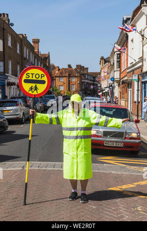 England, Berkshire, Eton, Eton High Street, Lollipop Lady Holding Stop-Schild Stockfoto