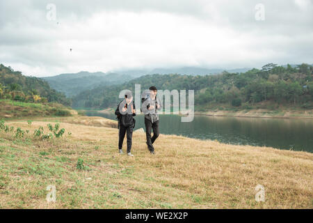 Zwei asiatische Reisende in der Nähe von See an einem sonnigen Tag Stockfoto