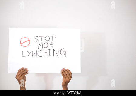 Hände mit Plakat zeigen von Stop Mob Lynchmord an isolierten Hintergrund. Stockfoto