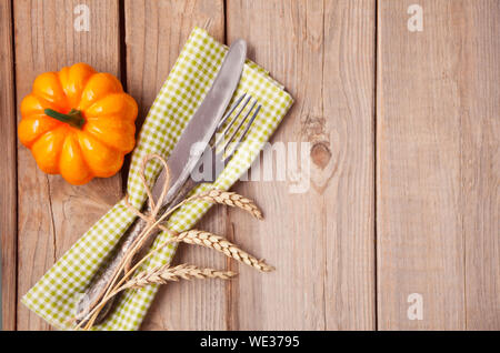 Holztisch mit Besteck, kleiner Kürbis und Weizen. Herbst Ernte. Herbst Konzept. Tischdekoration. Ansicht von oben. Stockfoto