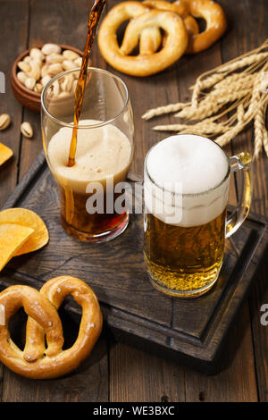 Verschiedene Arten von frisch gezapften Bier - Licht und Dunkel und Snack. Dunklen Hintergrund. Stockfoto