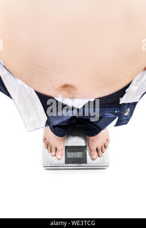 Blick von oben auf ein junger Mann mit großen Magen und gewichtsprobleme stehen auf einer Skala, die auf weißem Hintergrund. Stockfoto