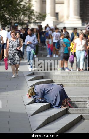 London, England, UK. Obdachlose Frau Betteln auf die Schritte in Peter's Hill, St Paul's Cathedral Stockfoto