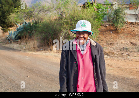 Ramabanta, Lesotho - September 20, 2017: lustig lächelnd afrikanische Frau in hellen Kleid auf authentischen Dorf Straße, alte glücklich lachend basotho Frau Stockfoto
