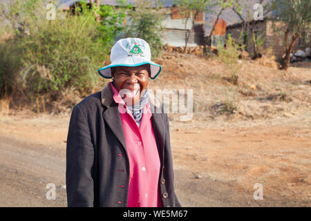 Ramabanta, Lesotho - September 20, 2017: lustig lächelnd afrikanische Frau in hellen Kleid auf authentischen Dorf Straße, alte glücklich lachend basotho Frau Stockfoto
