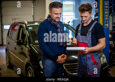 Mechaniker erklärt Auto reparieren Planen Sie einen Client Stockfoto