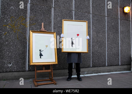 London, Großbritannien. 30 Aug, 2019. Der Christie Mitarbeiter wirft mit Kunstwerken" Mädchen mit Ballon - Farbe AP (Gold)" (L) und "Mädchen mit Ballon" durch anonyme Street Artist Banksy an der Southbank Centre in London Freitag, 30. August 2019. Die Southbank Centre wurde in der Nähe einer der ursprünglichen Standorte die Kunstwerke in London erschien. Die Drucke werden auf Verkauf nur während einer Online Auktion mit dem Titel 'Banksy: Ich kann nicht glauben, dass sie Idioten dieser Sh*t" von Christie's Auktionshaus zwischen 11-24 September 2019 vorgestellt. Foto Credit: Lukas MacGregor/Alamy leben Nachrichten Stockfoto