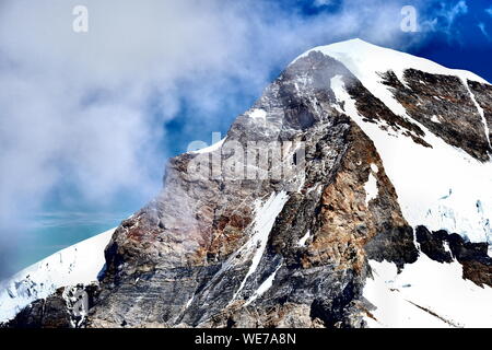 Der imposante, schneebedeckte Gipfel des Mönchs in den Schweizer Alpen erhebt sich majestätisch vor einem tiefblauen Himmel, der von leichten Wolkenschwaden durchzogen ist Stockfoto