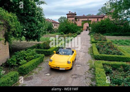 Italien, Emilia Romagna, Polesine Zibello in der Nähe von Parma, Antica Corte Pallavicina Hotel und Restaurant, Alfa Romeo Duetto Spider gelb Cabrio (Luftbild) Stockfoto