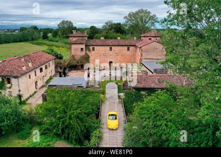 Italien, Emilia Romagna, Polesine Zibello in der Nähe von Parma, Antica Corte Pallavicina Hotel und Restaurant, Alfa Romeo Duetto Spider gelb Cabrio (Luftbild) Stockfoto