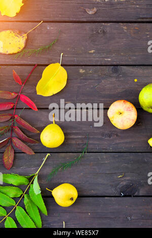 Äpfel und Birnen auf einem hölzernen Hintergrund Stockfoto