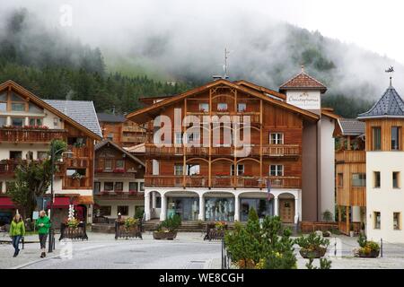 Italien, Autonome Provinz Bozen, San Vigilio, Holz- Chalets in der Innenstadt mit der Seite eines grünen Berg im Hintergrund Stockfoto