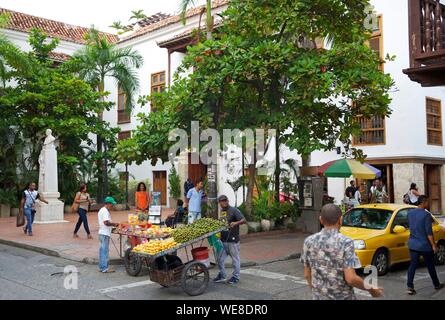 Kolumbien, Bolivar, Cartagena, als Weltkulturerbe von der UNESCO, Straßenhändler ziehen eine Frucht Warenkorb in der Mitte vorbei Vor von Juan Valdez Plaza de la Universidad Stockfoto