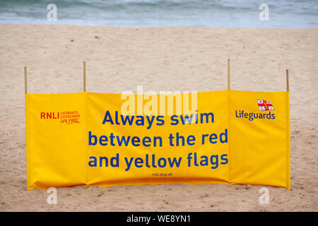 Warnhinweis am Strand von coldingham Bay, schwimmen immer zwischen dem roten und gelben Flaggen. Stockfoto