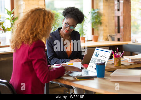 Interior Designer mit ihren Laptops während der Kontaktaufnahme mit Kunden Stockfoto