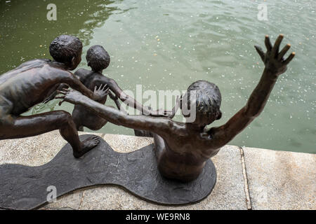 Erste Generation Bronze Skulpturen als Teil der Menschen der Fluss Serie von artist Chong Fah Cheong auf dem Singapore River, Singapur Stockfoto