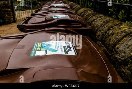 Eine Linie der braune Gartenabfälle wheelie Bins außerhalb einer gemeinschaftlichen Garten. Stockfoto