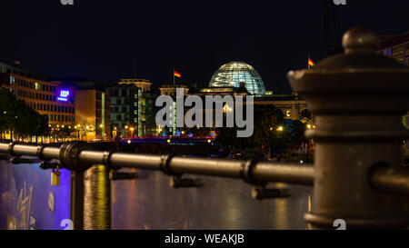 Berlin, Deutschland - 25 August 2019 - Deutscher Bundestag, Sitz des Parlaments, mit Brücke und ein unscharfes Zaun im Vordergrund bei Nacht Stockfoto