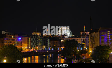 Berlin, Deutschland - 25 August 2019 - Deutscher Bundestag, Sitz des Parlaments, mit Brücke und ein unscharfes Zaun im Vordergrund bei Nacht Stockfoto