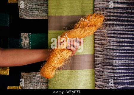 Hand, die natürliche gelbe Seide Faser. Rohstoff der traditionellen Seidenraupenzucht Thai Seide machen Stockfoto