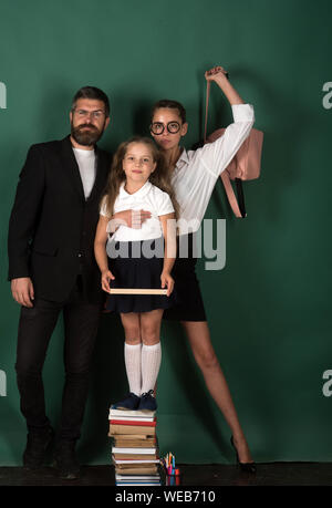 Die Leute Wissen und Bildung in der Schule - glückliche Schüler Mädchen und junge Frau mit Buch in der Bibliothek in der Nähe der Lehrer Mann. Stockfoto