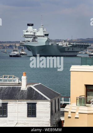 Mitgliedern der Besatzung stehen auf Deck als HMS Queen Elizabeth segeln von Portsmouth Naval Base setzt, für den Einsatz in die Vereinigten Staaten. Stockfoto