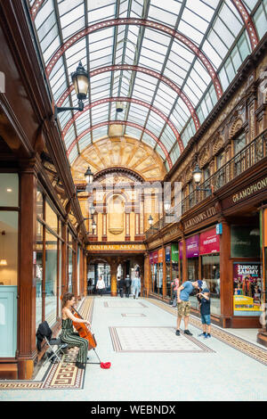 Weibliche Gaukler spielen Chello in der Arcade in Newcastle upon Tyne. England. Großbritannien Stockfoto