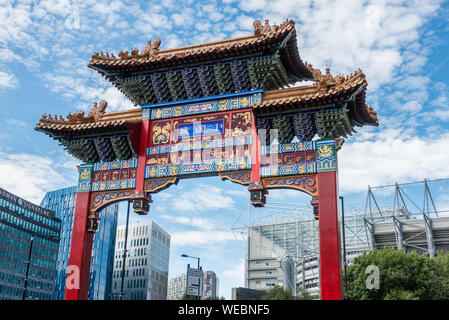 Eingang zu Chinatown in Newcastle mit modernen Gebäuden und Newcastle United Stadion im Hintergrund. Newcastle upon Tyne, England, Großbritannien Stockfoto