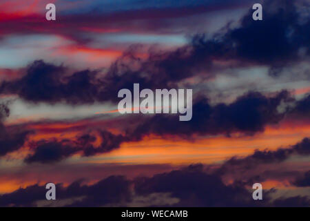Dramatischer Sonnenuntergang mit dunklen Wolken-rosa Wolken - rote Wolken - orange Wolken während der Blauen Stunde - bunten karibischen Sonnenuntergang Stockfoto