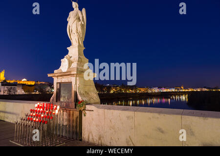 Cordoba, Spanien, 2,2014; Kerzen und Statue des Erzengels St. Gabriel an der Römischen Brücke. Stockfoto